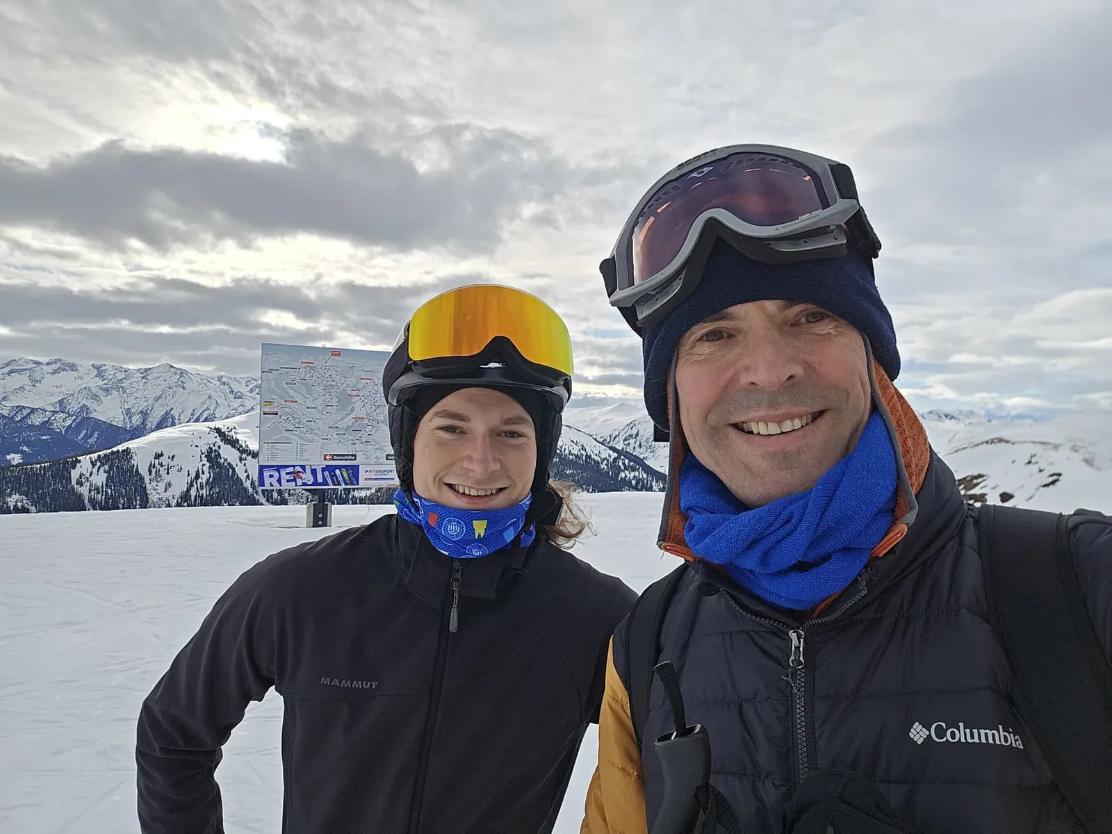 Gerald und ein Freund lächeln mit Skibrillen in die Kamera, dahinter Berge