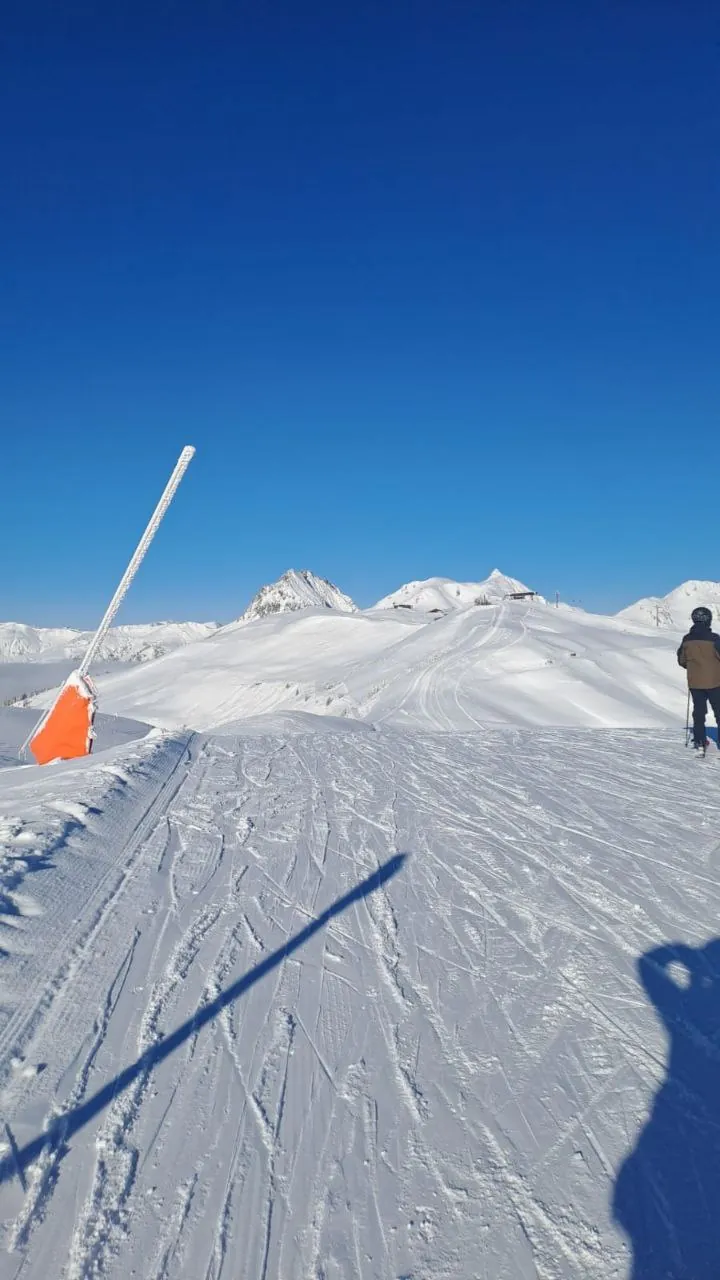 Präparierte Skipiste unter blauem Himmel