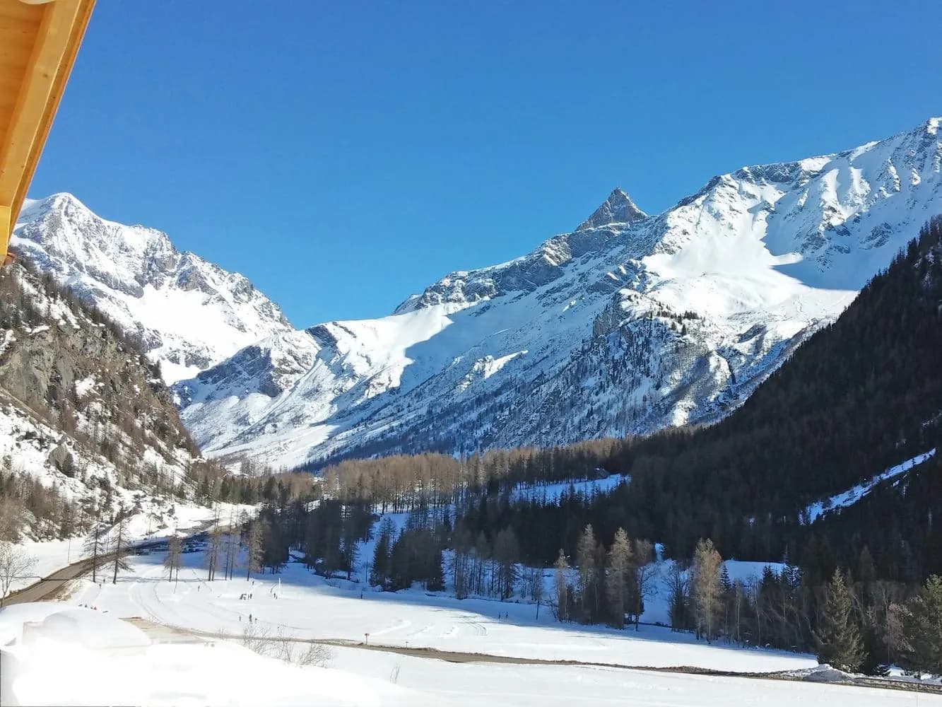Blick vom Chalet Cairn ins verschneite Tal auf die Dreitausender