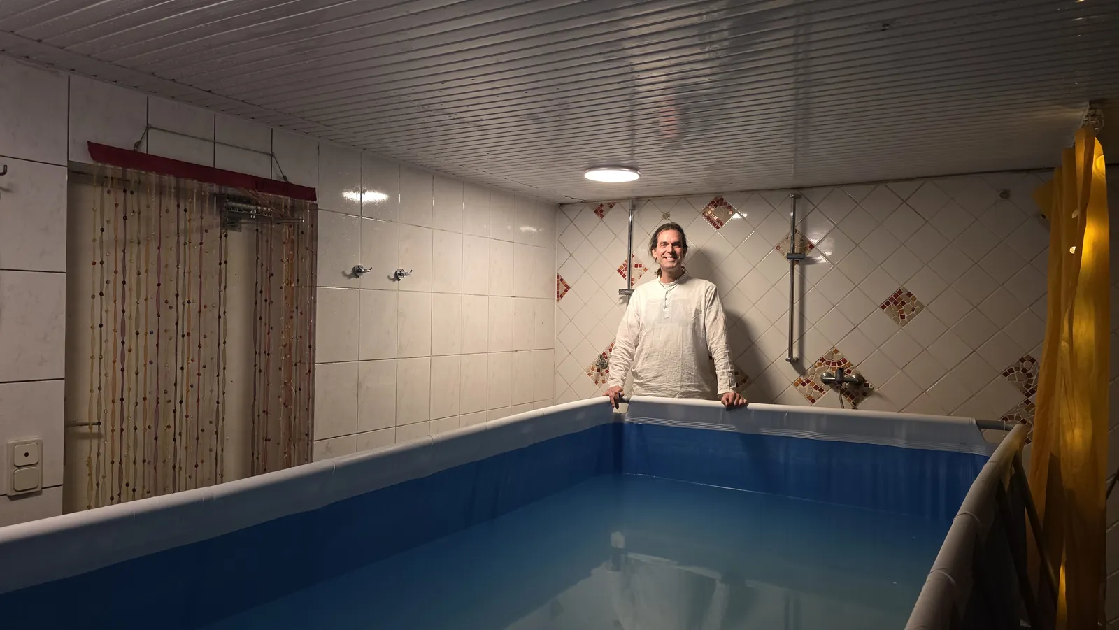 Gerald steht am Beckenrand des Pools für die Öl-Delfin-Massage